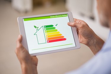 Two hands holding a tablet, the screen displaying an energy efficiency guide