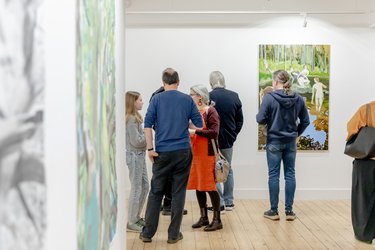 People discuss and look at art at Broadway Gallery