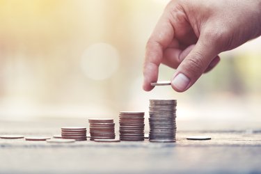 A stock image of a hand stacking coins