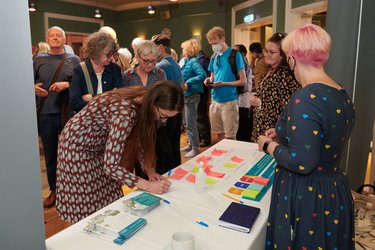 People write on post it notes to provide feedback at the Garden City Meeting