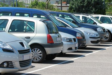 A row of cars parked alongside each other in a public car park