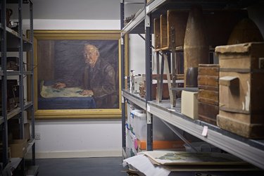 Various old objects in storage at the Collection, including a painting of Ebenezer Howard.