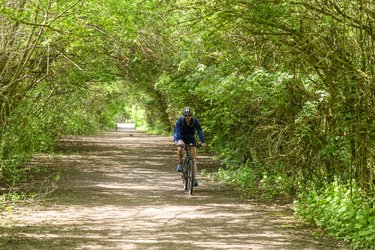 A man riding a bike through a green space in Letchworth